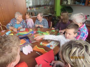 Prebivalci doma starejših občanov in otroci za mizo