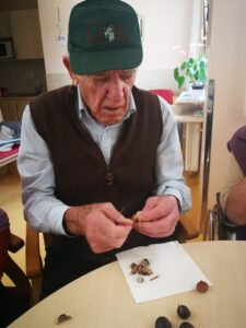 Prebivalci doma starejših občanov z demenco pripravljajo kuhan kostanj