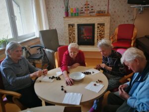 Prebivalci doma starejših občanov z demenco pripravljajo kuhan kostanj